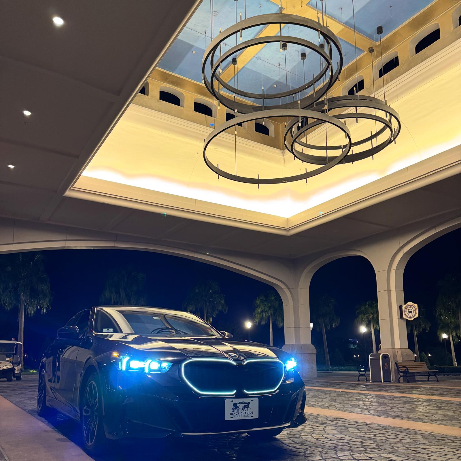 Black BMW luxury sedan at a resort entrance for Black Chariot contact page